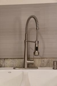 a kitchen sink with a chrome kitchen faucet at Infinity Suites Habitación Triple 105 in Cancún