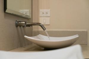 a sink with a water faucet in a bathroom at Infinity Suites Habitación Triple 105 in Cancún