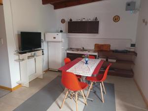 eine Küche mit einem roten Tisch und roten Stühlen in der Unterkunft Casita del Río in Santa Rosa de Calamuchita