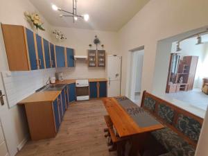 a kitchen with blue cabinets and a wooden table at WlodawaSpot in Włodawa