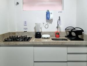 a kitchen counter with a stove and a sink at Apartamento c Wi-fi Rápida no melhor da PontaVerde in Maceió +10 photos