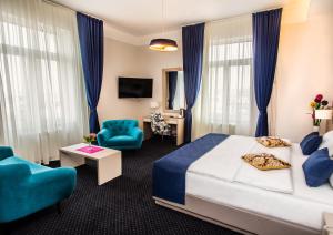 a hotel room with a bed and a blue chair at Five Points Square - City Center in Belgrade