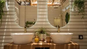 un bagno con due lavandini di fronte a uno specchio di Mini Villa ATIKA Luxe Tropical pour Deux a Ducos