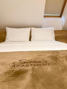 Una cama con almohadas blancas y un cartel que dice shakespeareauderauder en Siera's Apartment, en Pristina 12 fotos más