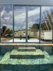 un riflesso di un divano in una finestra di Mini Villa ATIKA Luxe Tropical pour Deux a Ducos