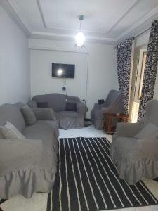 ein Wohnzimmer mit zwei Sofas und einem Fernseher in der Unterkunft شقه مفروشة علي البحر عائلات فقط in Alexandria