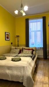 two beds in a room with yellow walls and a window at Riga Central District, Тихий Центр города, всё под боком, удобно in Rīga