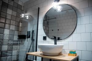 a bathroom with a sink and a mirror at Aparthotel Luz de Gades - Suites Spa Gym - Adults Only in Cádiz