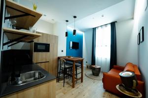a kitchen and living room with a sink and a couch at Aparthotel Luz de Gades - Suites Spa Gym - Adults Only in Cádiz