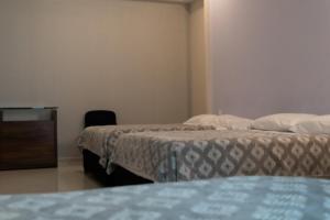 a hotel room with two beds and a television at Infinity Suites Habitación Triple 212 in Cancún