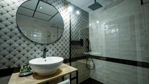 a bathroom with a sink and a mirror at Aparthotel Luz de Gades - Suites Spa Gym - Adults Only in Cádiz
