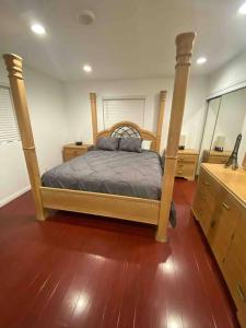 a bedroom with a bed and a wooden floor at Beautiful 4 bedroom 2 bathroom house in Gardena