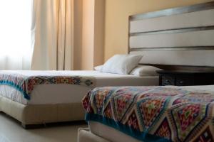 En eller flere senge i et værelse på Infinity Suites Habitación Doble 202