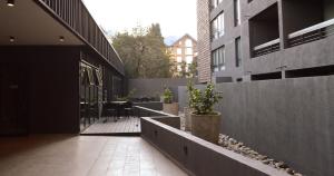 une cour d'un immeuble avec une table et des chaises dans l'établissement Hermoso Depto Nuevo 3D 2B y Litera Vista al Lago con Piscina Temperada , Jacuzzi, à Puerto Varas