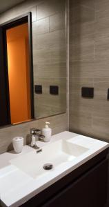 une salle de bain avec un lavabo blanc et un miroir dans l'établissement Hermoso Depto Nuevo 3D 2B y Litera Vista al Lago con Piscina Temperada , Jacuzzi, à Puerto Varas