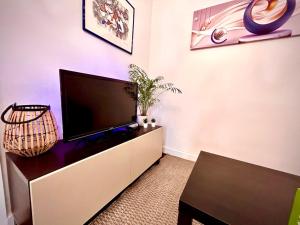 a living room with a flat screen tv on a cabinet at Casinha Margarida in Adaúfe +10 photos