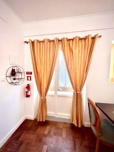a window with curtains in a room with a table at Casinha Margarida in Adaúfe
