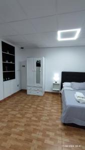 a bedroom with a bed and a wooden floor at Estudio Santa Catarina in Málaga