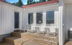 a deck with chairs and windows on a house at Stunning Home In Färgelanda in Färgelanda