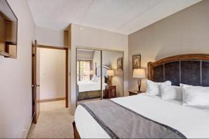 a bedroom with a large bed and a mirror at 2 Bedroom Ski In, Ski Out Mountain Vacation Rental Located Next To Historic Main Street In Downtown Breckenridge in Breckenridge +17 photos