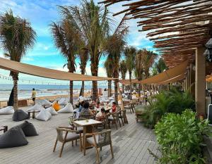 a group of people sitting at tables on the beach at Novaworld Beach villa in Phan Thiet