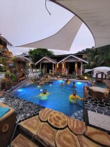 eine Gruppe von Menschen, die in einem Schwimmbecken schwimmen in der Unterkunft Tamara Resort Motel in Tioman Island