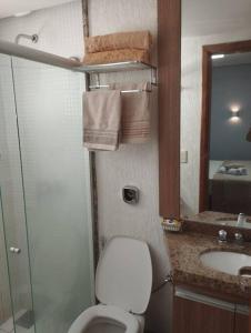 een badkamer met een toilet, een wastafel en een spiegel bij Studio Urbano Sun Square hotel in Goiânia