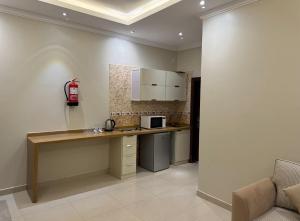 a kitchen with a counter with a microwave on the wall at نزل ارام النفل Nozol Aram 4 in Riyadh