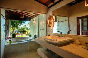 a bathroom with a large sink and a tub and a tubermott at Pousada Villa Tainá - Arraial d'Ajuda, Bahia in Arraial d'Ajuda