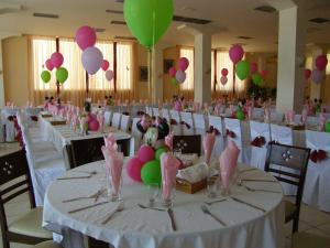 um salão de banquetes com mesas brancas com balões rosa e verde em Hotel Kiani Akti em Selianitika