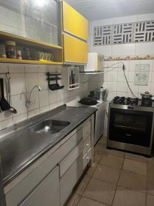 a kitchen with a sink and a stove at Paraíso dos Oliveiras - Ponta de Pedras in Goiana