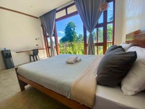 卢纳将军城isla Siargao Stays的一间带大床和大窗户的卧室
