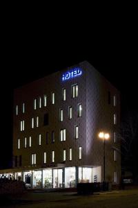 a hotel building with aigil sign on it at night at Hotel Olympia in Kopřivnice