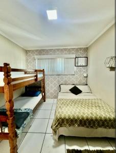 a bedroom with a bed and a bunk bed at Acquamarine Hospedagem Apartamento c 2 quartos e suites para casal in Arraial do Cabo