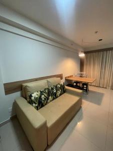 una sala de estar con un sofá y una mesa en Rio Quente Park Veredas Flat - Proximo ao Hot Park - Acesso ao rio - A1, en Rio Quente