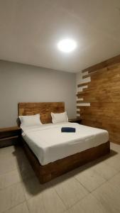 une chambre avec un grand lit avec une tête de lit en bois dans l'établissement Angin Mamiri Rinjani Cottages And Restaurant, à Senaru