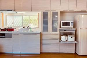 a kitchen with white appliances and a white refrigerator at 星光の城 船でアクセス友人との集まりに最適なリラックスできる秘境 in Hinase +15 photos