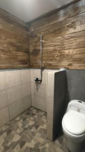 une salle de bain avec des toilettes blanches et des murs en bois dans l'établissement Angin Mamiri Rinjani Cottages And Restaurant, à Senaru 79 autres photos
