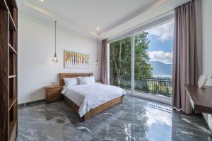 a bedroom with a bed and a large window at Adara Lake View Residence Bedugul - Bali in Bedugul +24 photos