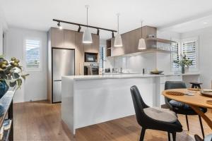 a kitchen with a counter and a table with chairs at Wanaka Station Apartment in Wanaka +8 photos