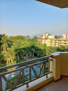 a balcony with a view of palm trees and buildings at Hue Vinh Hotel in Thương Xà (2)