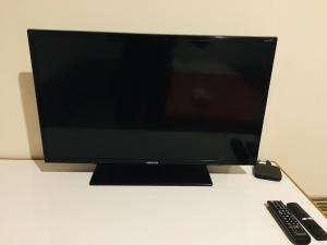 a television sitting on a table with a remote control at Munay in Tacna