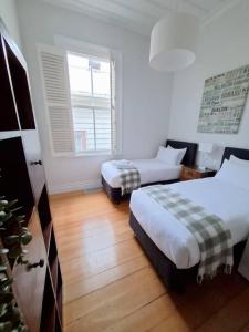 a hotel room with two beds and a window at Grafton House Villa Oasis, Central Auckland in Auckland +12 photos