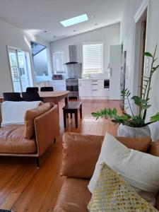a living room with two couches and a kitchen at Grafton House Villa Oasis, Central Auckland in Auckland