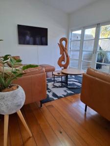 a living room with a couch and a chair at Grafton House Villa Oasis, Central Auckland in Auckland