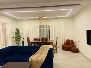 a living room with a blue couch and a table at Bhaktivilla in Talegaon Dābhāde