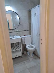 une salle de bain avec toilettes, lavabo et miroir dans l'établissement MDP Depto, à Mar del Plata