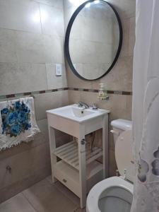 une salle de bain avec un lavabo, des toilettes et un miroir dans l'établissement MDP Depto, à Mar del Plata