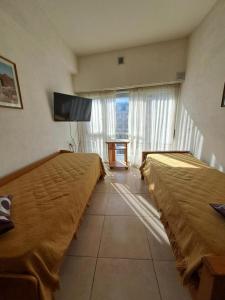 une chambre d'hôtel avec deux lits et une télévision dans l'établissement MDP Depto, à Mar del Plata
