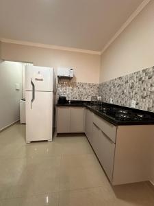 a kitchen with a white refrigerator in a room at Villa Santiago II in Manaus